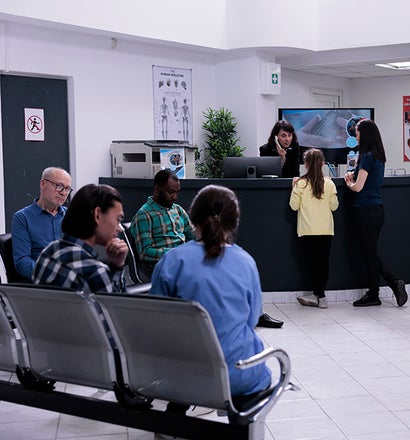 A group of people sitting in chairs in a waiting room